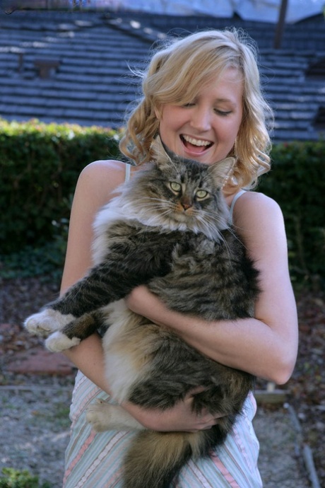 Blonde teen Kimber Clarkson hangs onto her cat before showing her tight slit