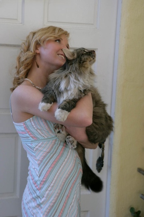 Blonde teen Kimber Clarkson hangs onto her cat before showing her tight slit