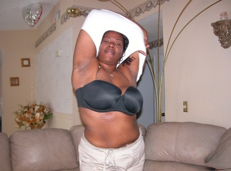 Ebony fatty fingers her shaved pussy after going bare naked