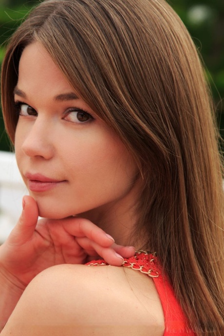 Beautiful teen Nedda A displays her trimmed muff after undressing in garden