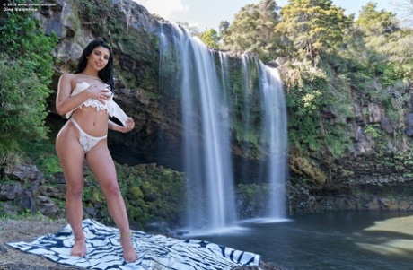 Brazilian babe Gina Valentina gets naked on a blanket in front of a waterfall