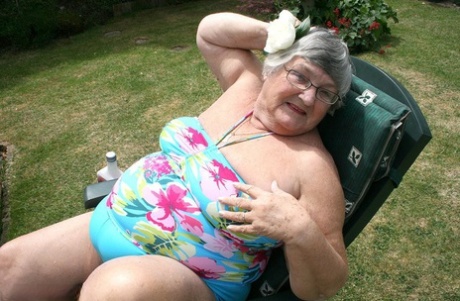 Naughty amateur granny Libby inserting a bottle in her fat pussy in the garden