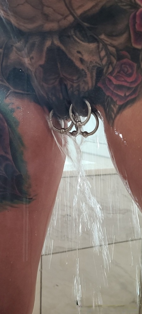 Tatted older woman Marie Bossette highlights her pierced pussy while showering