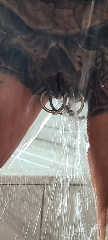 Tatted older woman Marie Bossette highlights her pierced pussy while showering