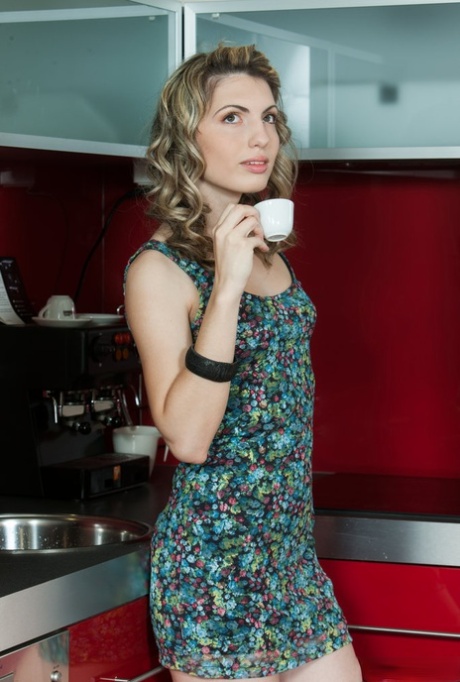 Sexy teen Maggie does away with a short dress to model naked in a kitchen