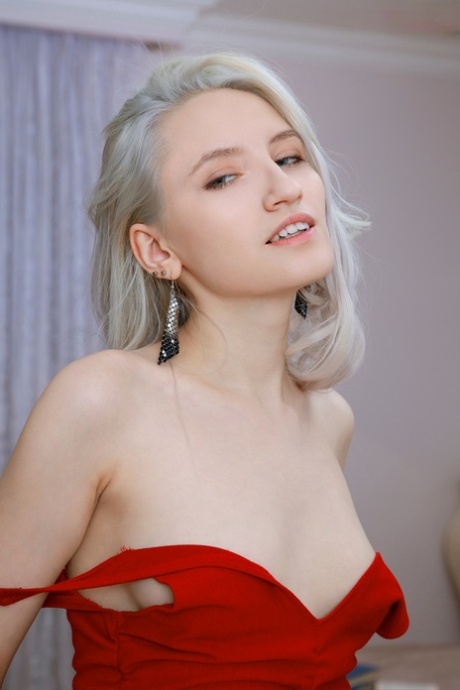 Platinum blonde teen Sofia takes off a red dress to model naked