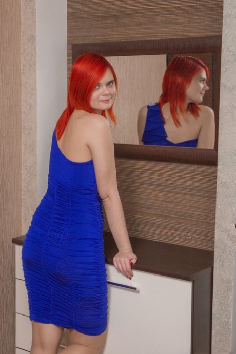 Redhead sweetie Ishtar strips her blue dress and flaunts her bush