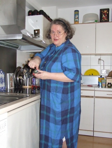 Fat mature housewife Birgid masturbates with a cucumber in the kitchen