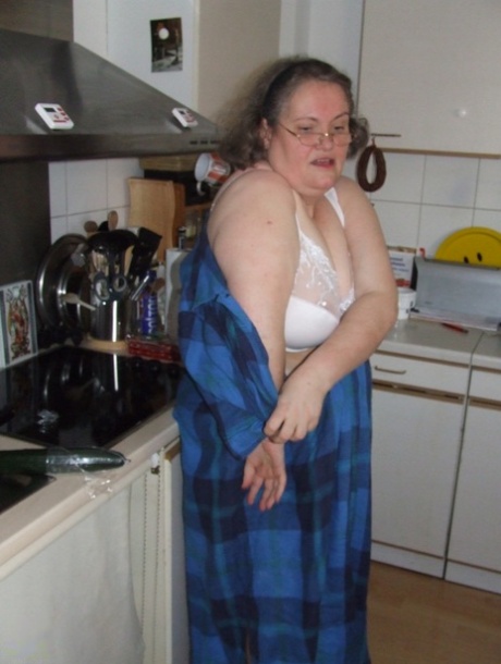 Fat mature housewife Birgid masturbates with a cucumber in the kitchen