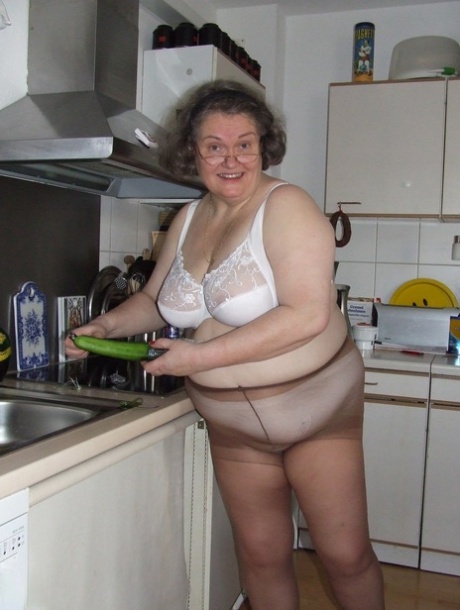 Fat mature housewife Birgid masturbates with a cucumber in the kitchen