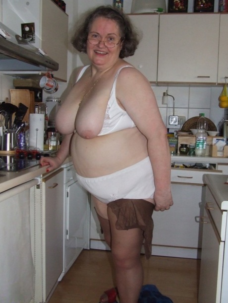 Fat mature housewife Birgid masturbates with a cucumber in the kitchen