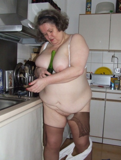 Fat mature housewife Birgid masturbates with a cucumber in the kitchen