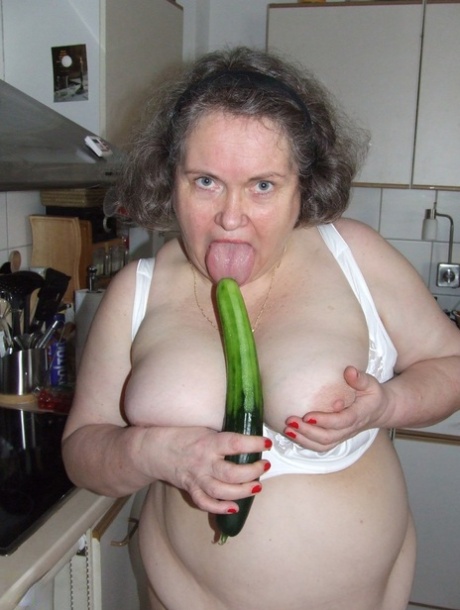 Fat mature housewife Birgid masturbates with a cucumber in the kitchen