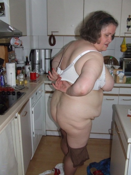 Fat mature housewife Birgid masturbates with a cucumber in the kitchen