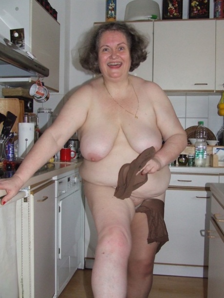Fat mature housewife Birgid masturbates with a cucumber in the kitchen