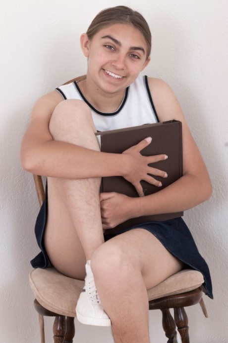 Modest teen Sunny smiles while showing her unshaved peach on camera