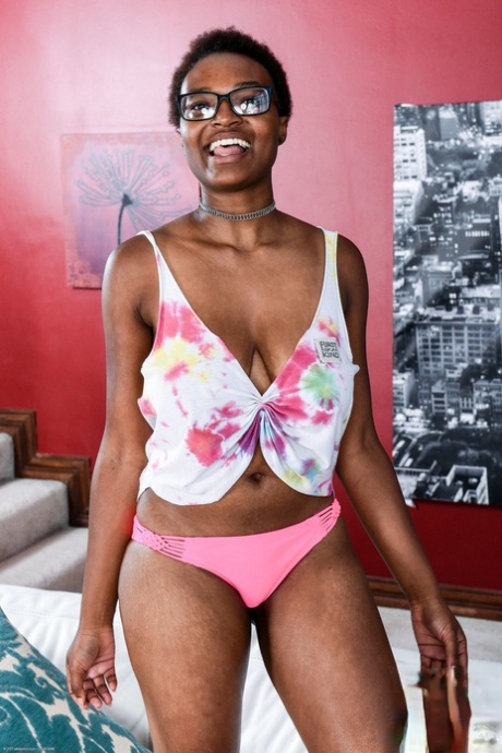Ebony in glasses Nadyia Foxxx strips and flaunts her big tits and tasty clam